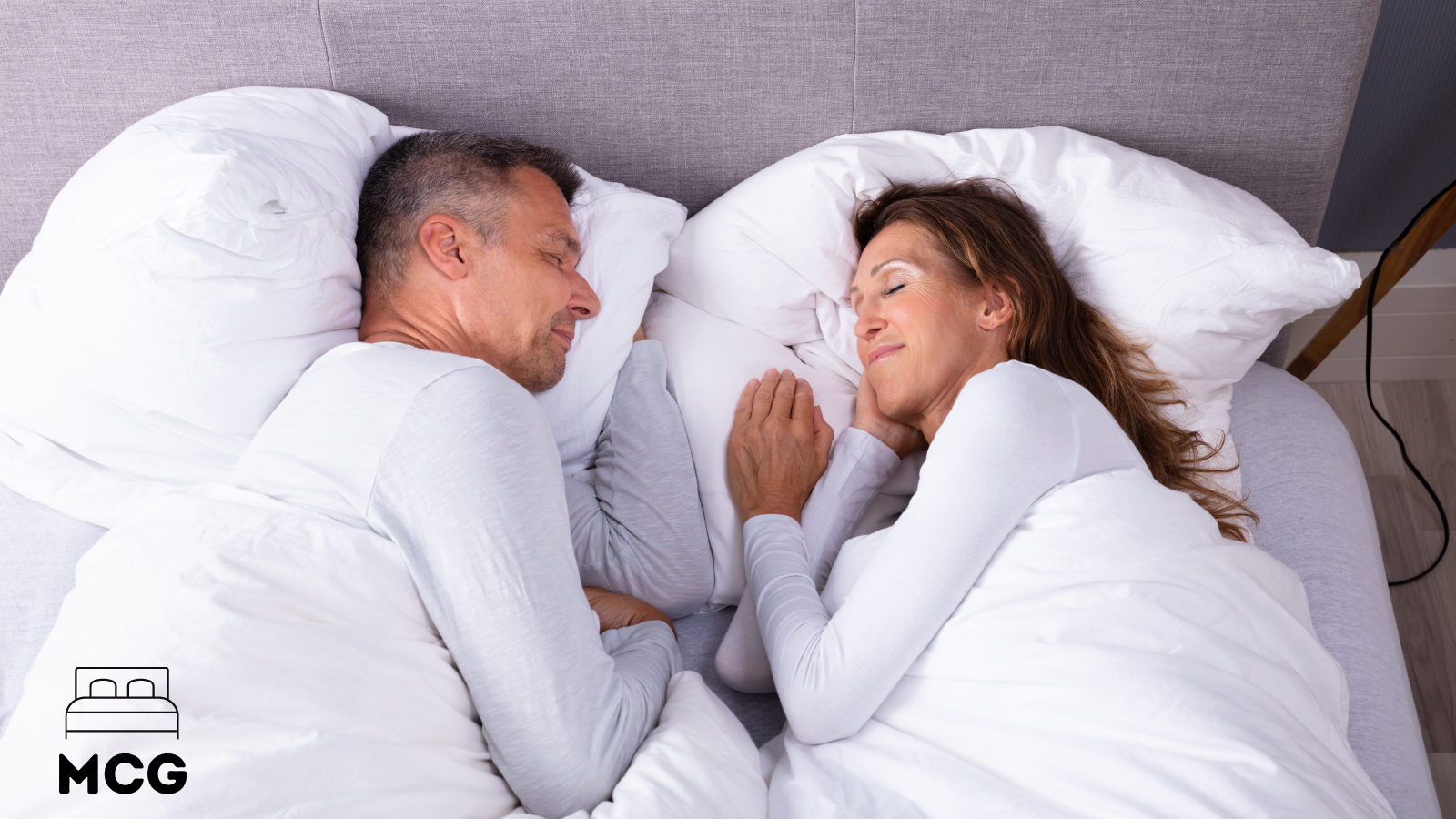 couple sleeping on a bed with a box spring