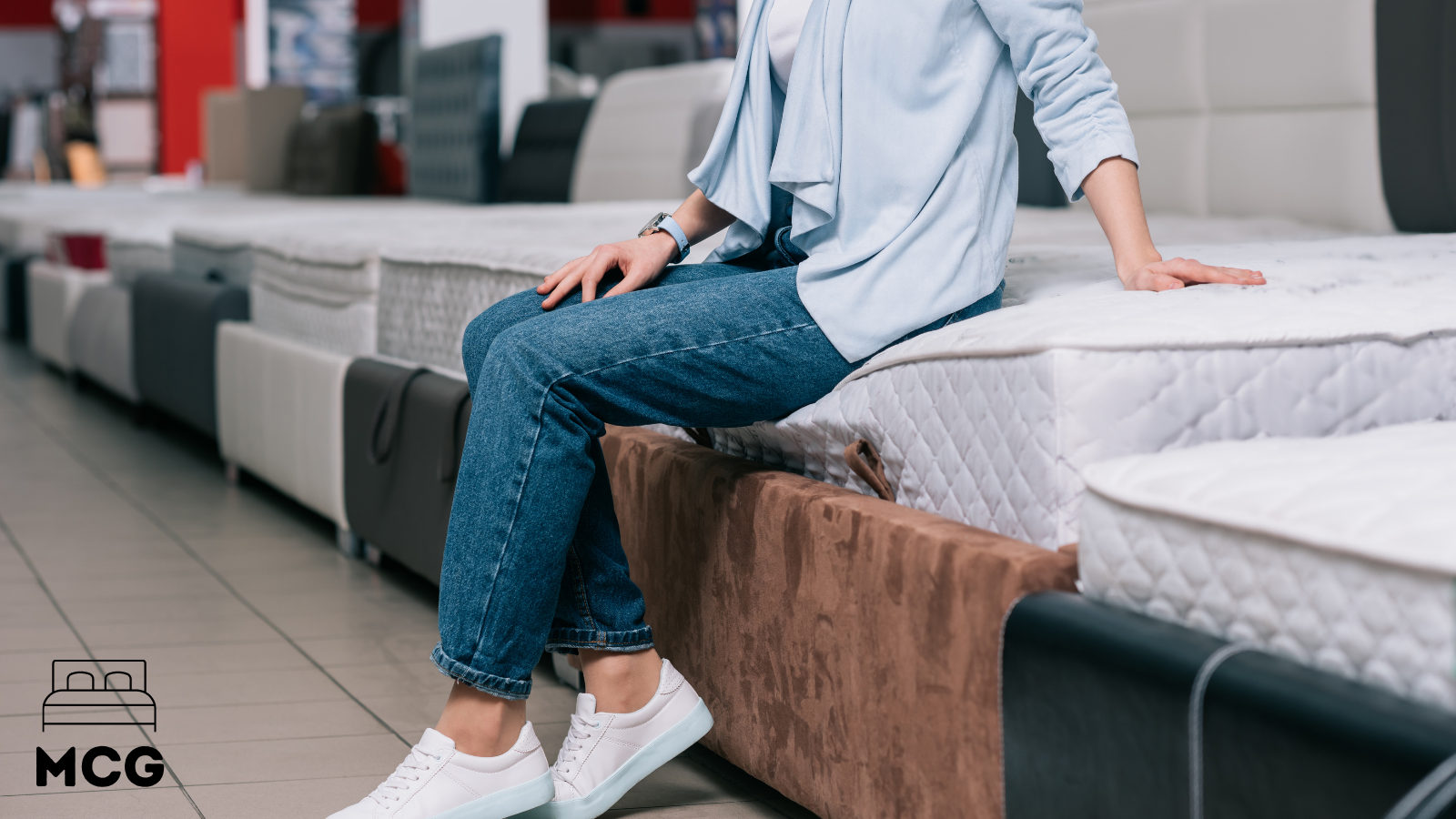 man sitting on edge of a memory foam mattress