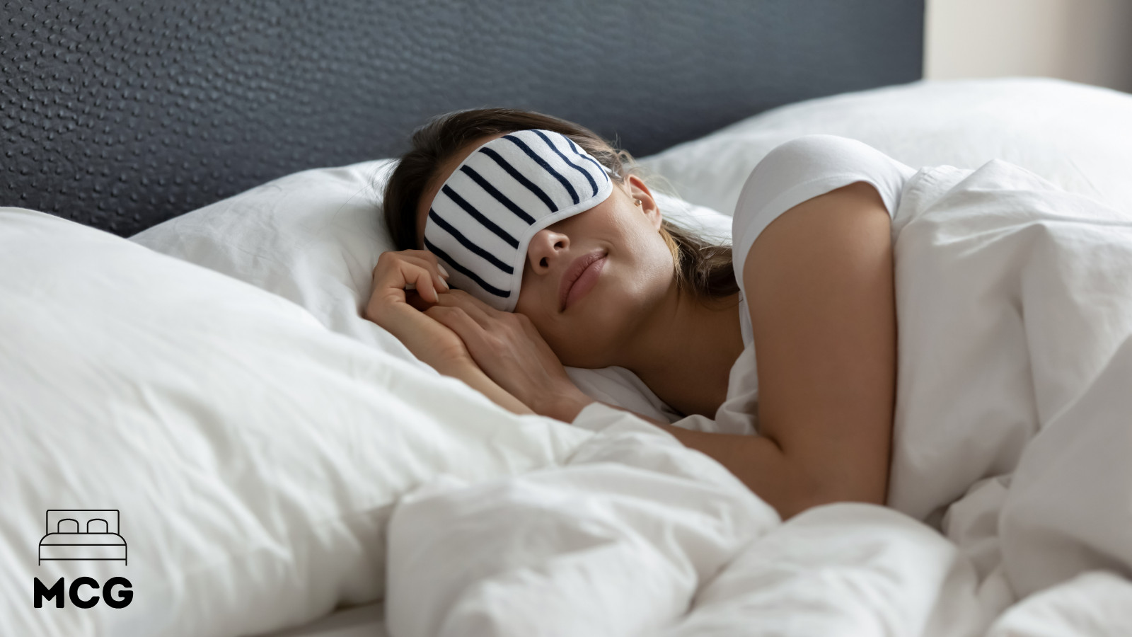 woman sleeping in a bed wearing a sleeping mask