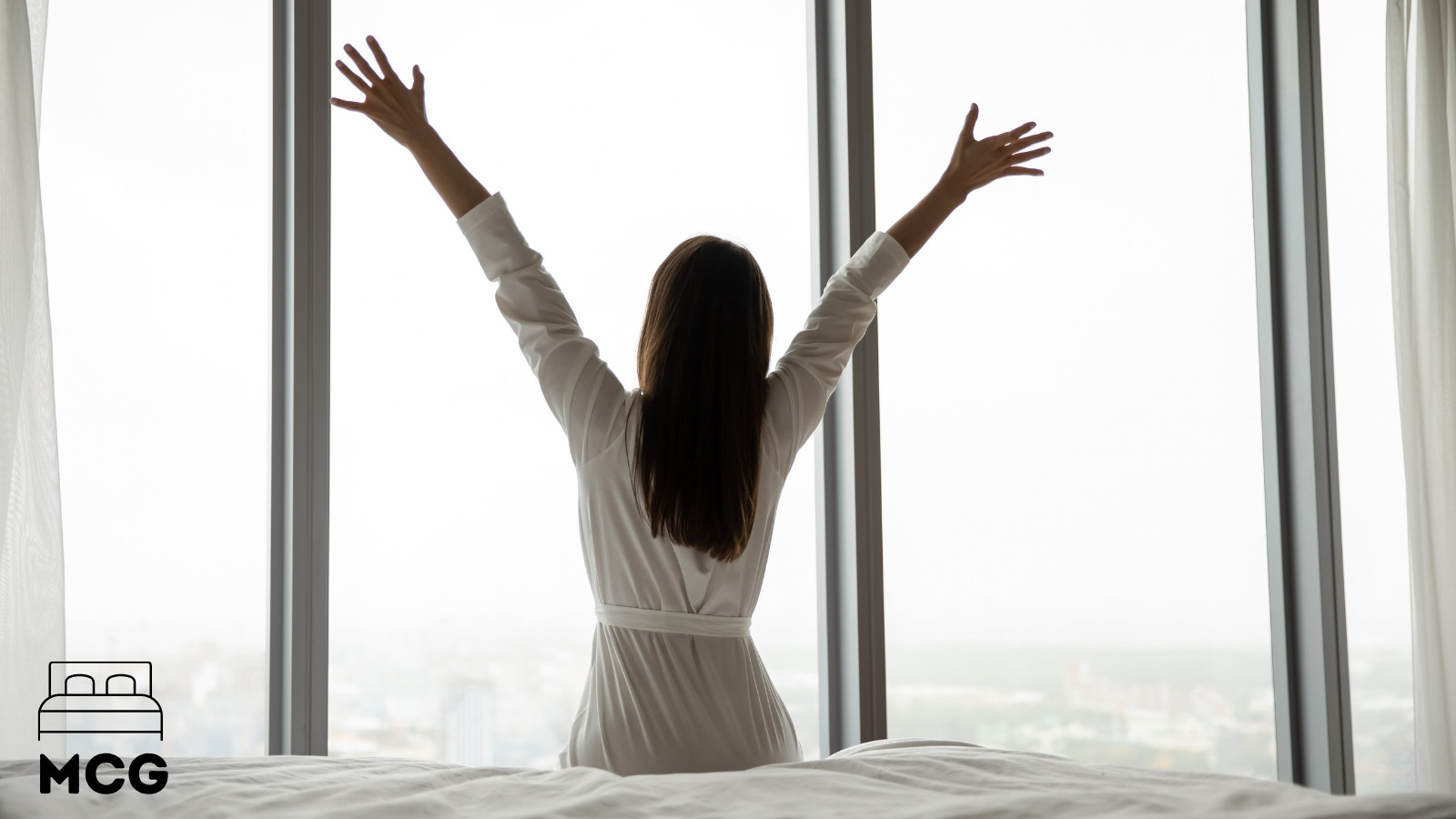 woman getting out of bed and stretching her arms