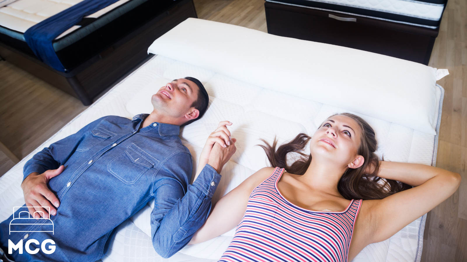 man and woman holding hands on a latex mattress