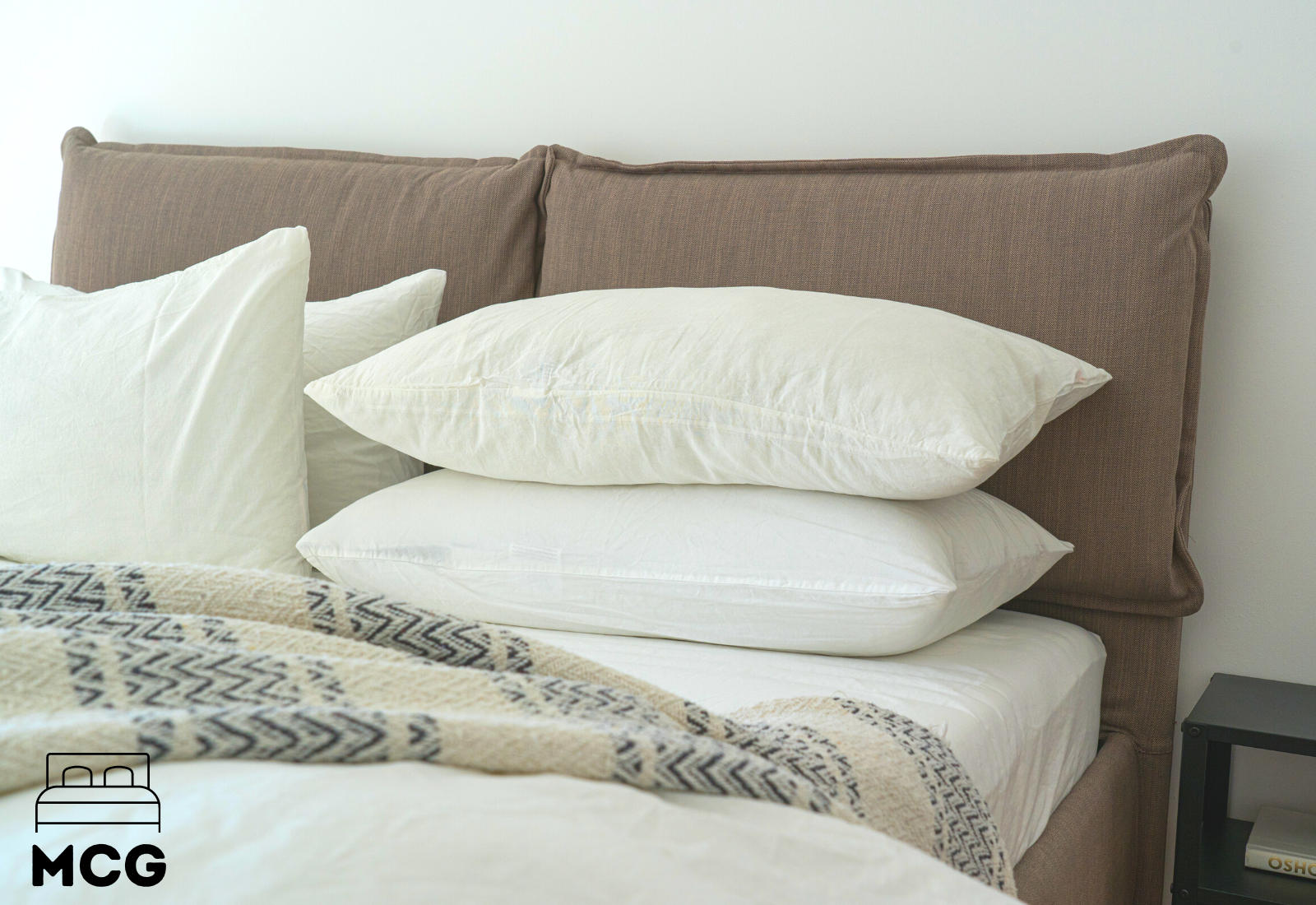 stack of down pillows on a bed