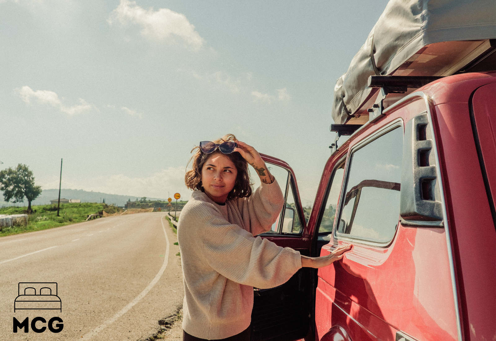 woman standing next to a red camper van