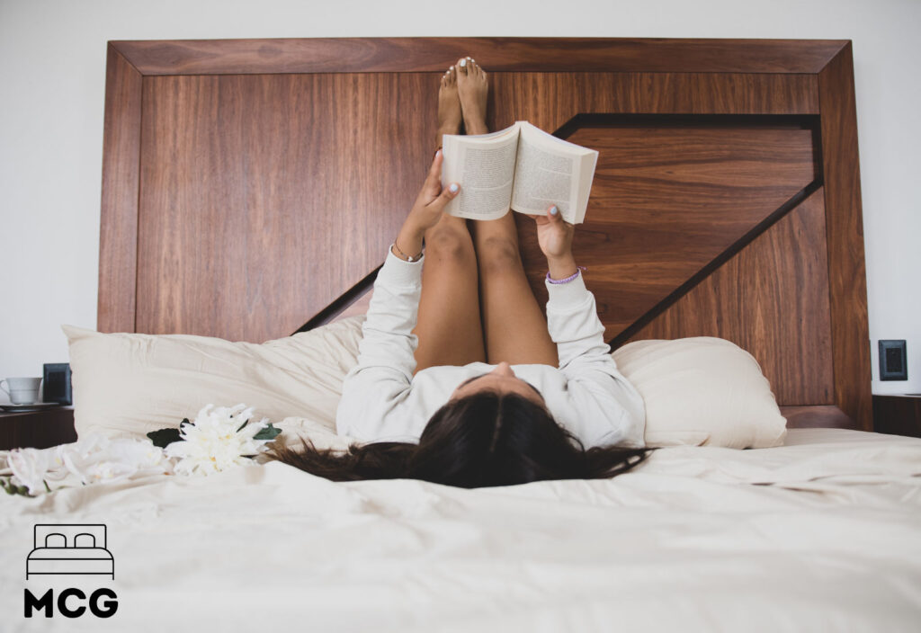 woman resting legs on a bed headboard