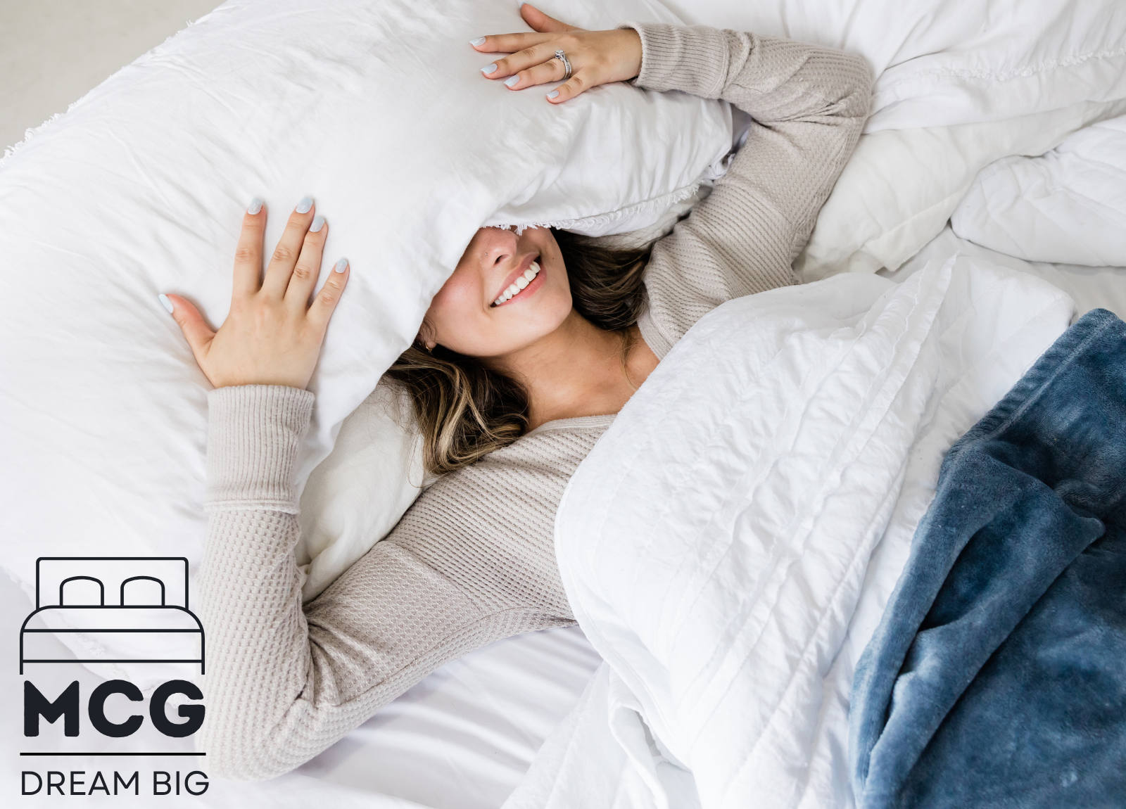 Woman in bed with pillow over head